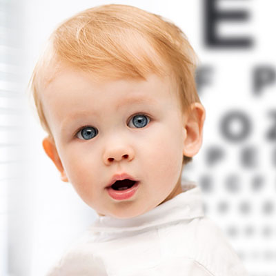 A child reading a letter chart during an eye test.